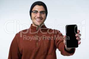 Smiling man in winter cloth holding mobile phone