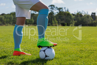 Football player standing with soccer in the ground