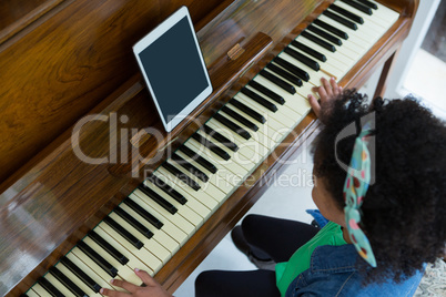 Girl playing piano with digital tablet