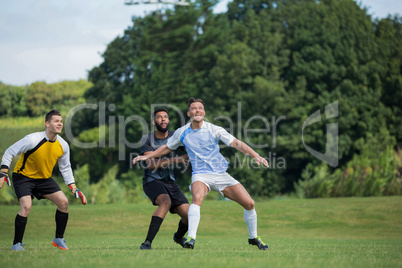 Football players playing soccer in the ground