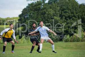 Football players playing soccer in the ground