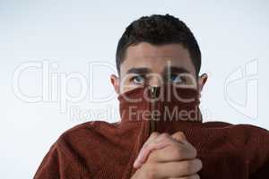 Scared man covering his mouth with turtle neck jacket