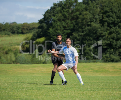 Football players playing soccer in the ground