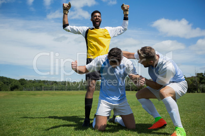 Excited football players celebrating after scoring the goal