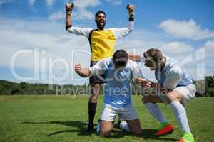 Excited football players celebrating after scoring the goal