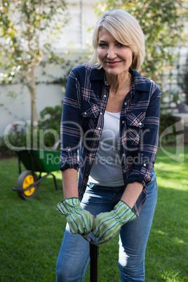 Beautiful woman standing with gardening equipment