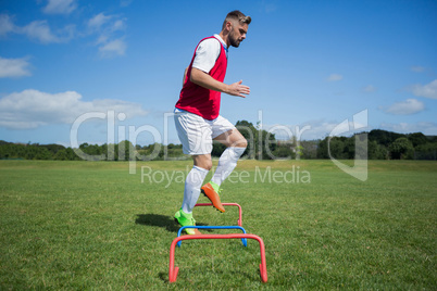 Soccer player practicing on obstacle