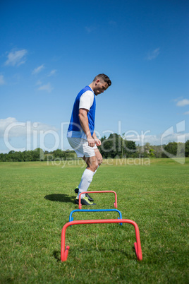 Soccer player practicing on obstacle