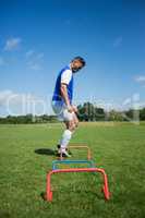 Soccer player practicing on obstacle