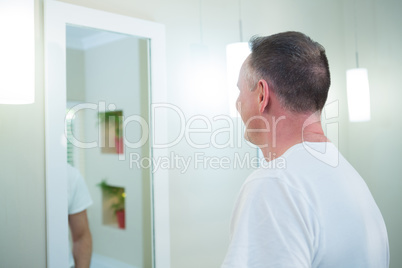 Man looking at mirror in bathroom