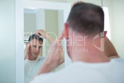 Man combing his hair in bathroom