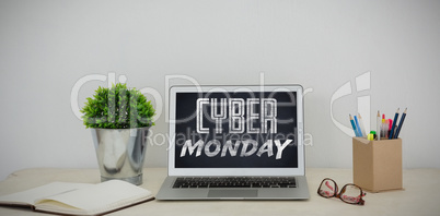 Composite image of laptop, pot pant, pencil holder, spectacles and organizer on table