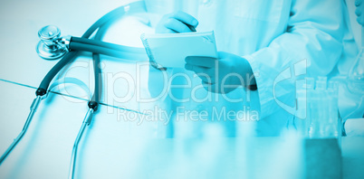 Composite image of stethoscope on desk