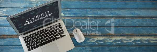 Composite image of laptop and mouse on wooden table