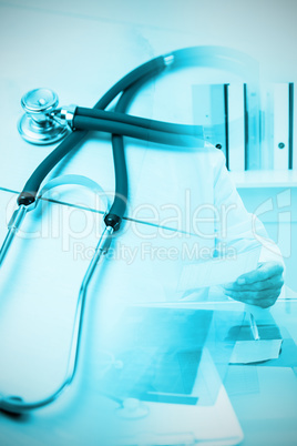 Composite image of stethoscope on desk