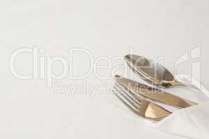 Fork, butter knife and spoon in napkin