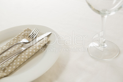 Fork and butter knife with napkin arranged in a plate