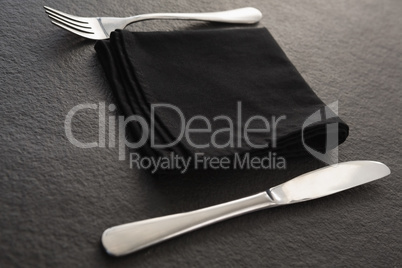 Fork, spoon and a black napkin on table