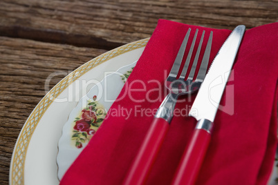 Fork and butter knife with napkin in a plate