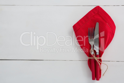 Fork and butter knife with napkin tied up with a rope