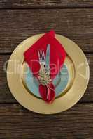 Fork and butter knife with napkin and christmas ornament tied up with a rope