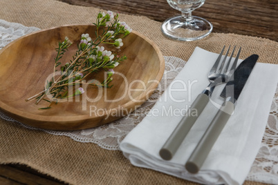 Flora arranged on plate with cutlery and napkin