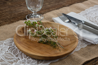 Flora arranged on plate with cutlery and napkin