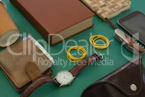 Disposable glass, wallet, organizer, wristwatch, pocketknife, mobile phone and sunglasses case on gr