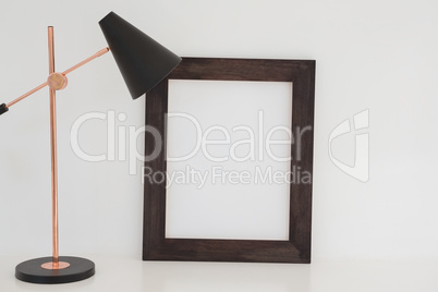 Table lamp and blank picture frame on table