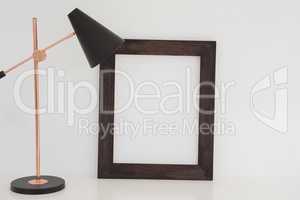 Table lamp and blank picture frame on table