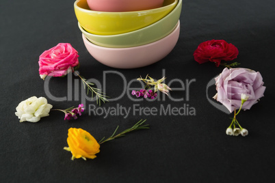 Bowls and flowers arranged on a black themed table