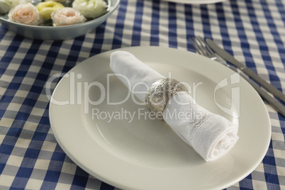 Rolled up napkin arranged on plate