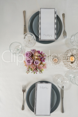 Menu card, plate and cutlery set elegantly on a table