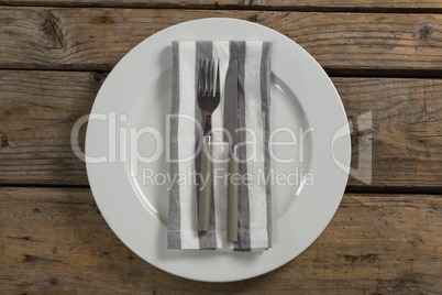 Fork and butter knife with napkin arranged in a plate