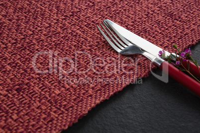Fork, butter knife with flower on placemat