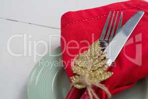 Fork and butter knife with napkin and christmas ornament tied up with a rope