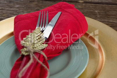 Fork and butter knife with napkin and christmas ornament tied up with a rope
