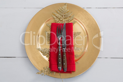 Cutlery with napkin and christmas decoration in a plate