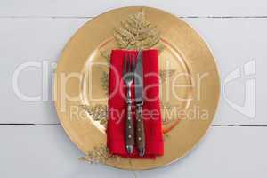 Cutlery with napkin and christmas decoration in a plate