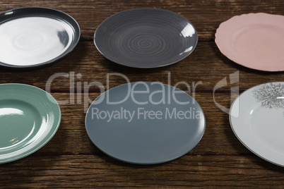 Various empty plates on wooden plank