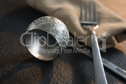 Napkin ring and cutlery on concrete background