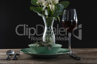 Setting a table for a dinner party with wine glass and flower vase