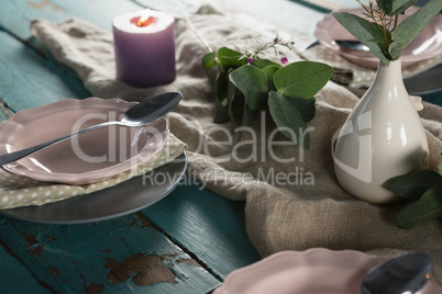 Elegance table setting with flower vase and lit candle
