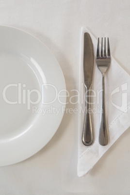 White plate and cutlery set on a table