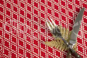 Christmas ornament with fork and butter knife on table cloth