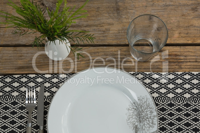 Fork and butter knife with plate arranged on table cloth