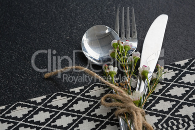 Spoon, fork, butter knife and flower tied up with rope