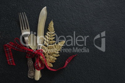 Cutlery with christmas ornament tied up with ribbon