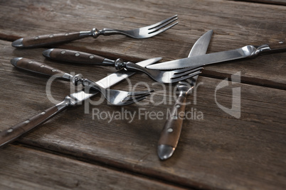 Various cutlery on wooden plank