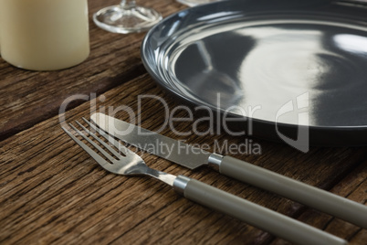 Plate and cutlery on wooden table